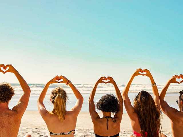 adolescents faisant des coeurs avec leurs mains sur la place en espagne été