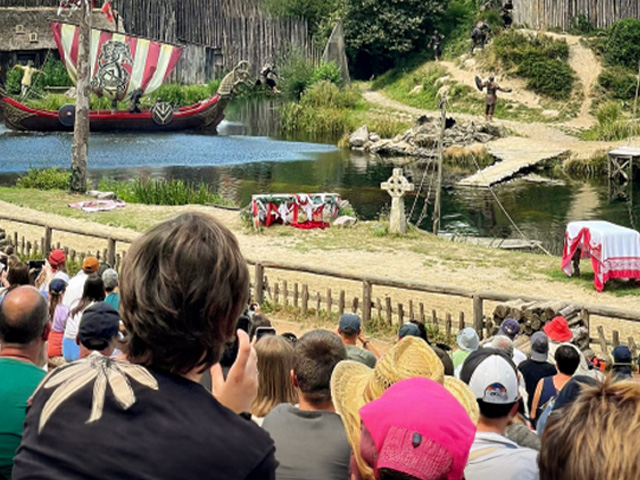 spectateurs au puy du fou regardant un spectacle insolite permettant un retour dans le passé