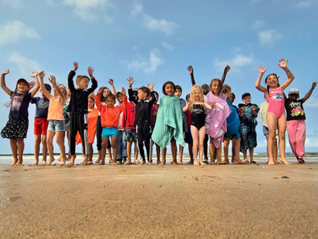 photo de groupe sur la plage avec des jeunes et leur serviette lors d'une colo en vendée