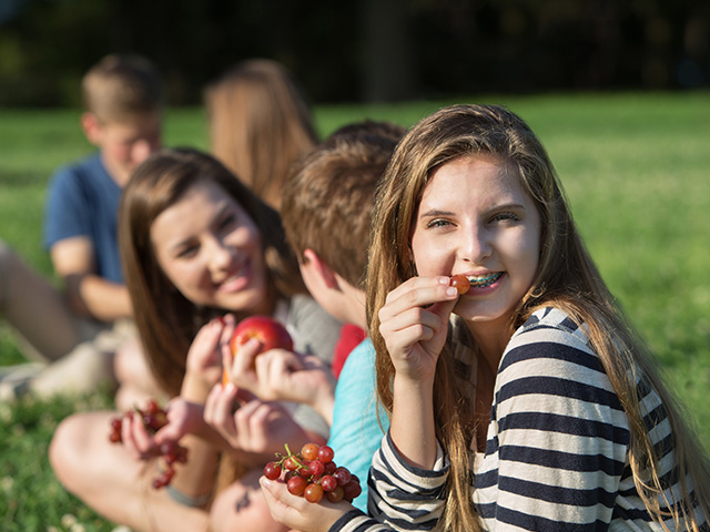 groupe de jeunes allongés sur l'herbe en plein été lors d'une colo