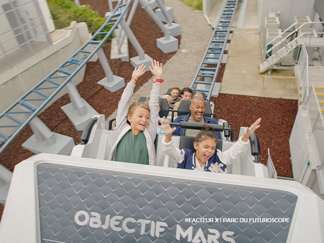 enfants les bras levés lors d'une attraction au futuroscope cet été