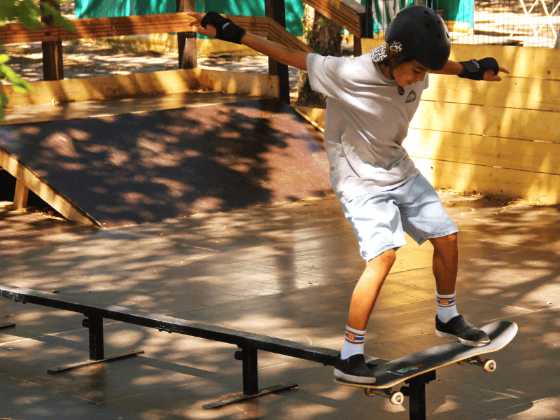 Jeune en colonie de vacances Skate qui s'essaye sur une rampe