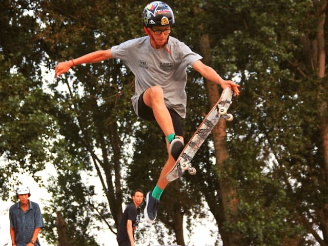 Jeune en colo qui fait une figure de skate cet été