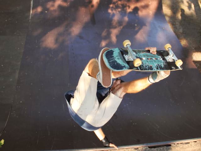 Jeune en colo qui fait une figure de skate cet été