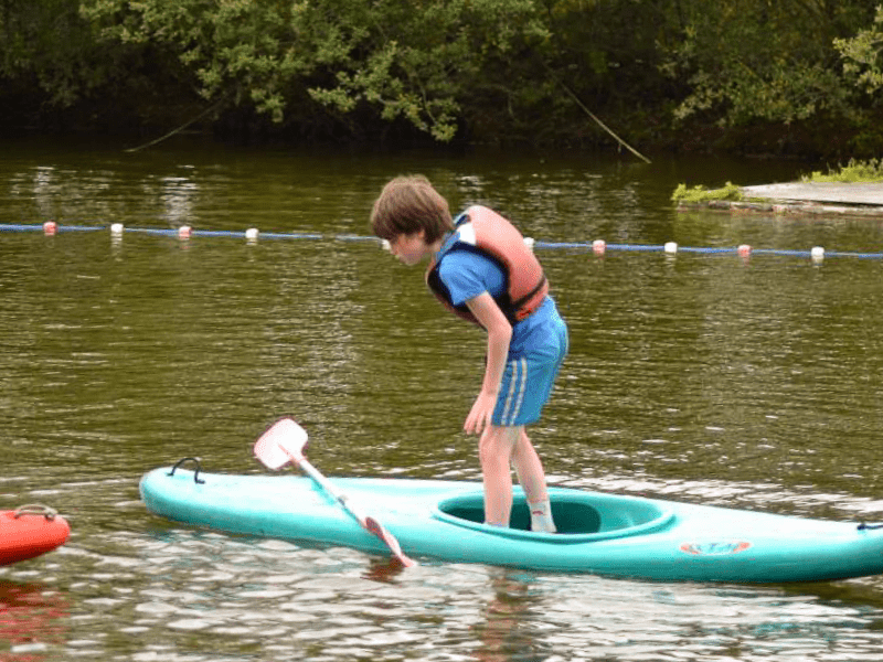Jeune garçon en colo de vacances en Normandie qui fait du canoe