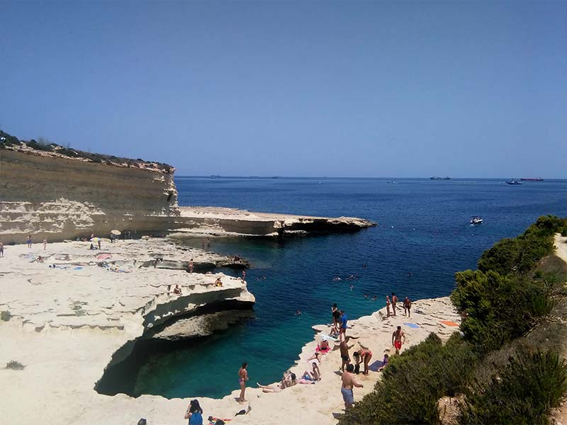 Crique à Malte avec vue sur la Méditerranée et les jeunes en colo de vacances qui profitent
