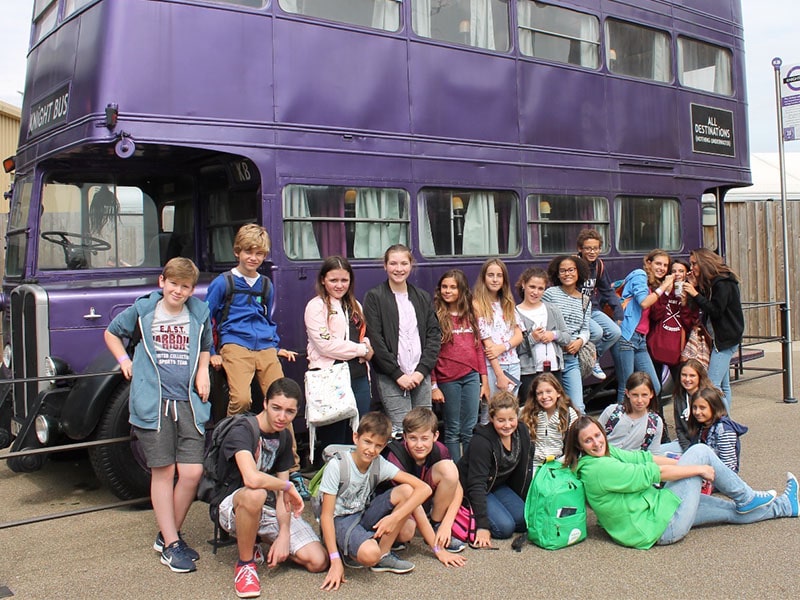 Groupe de jeunes ados devant le bus magique d'Harry Potter en colo de vacances à Londres cet été