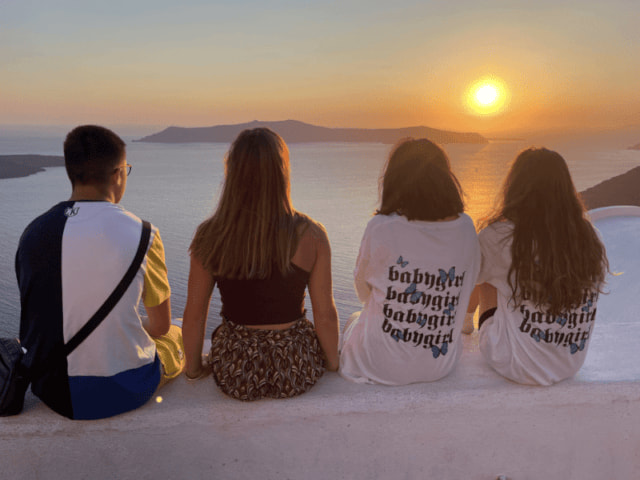 Ados qui admirent le couché de soleil en Grèce durant leur colo de vacances à l'étranger cet été