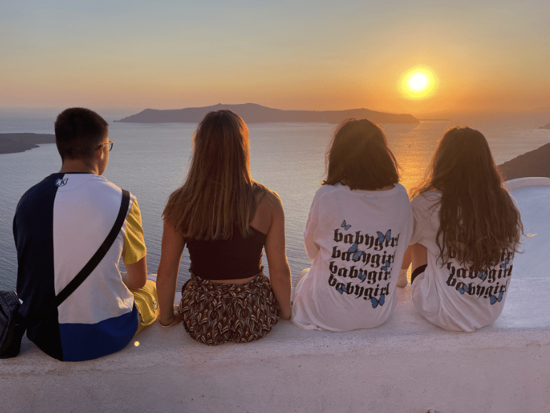 Ados qui admirent le couché de soleil en Grèce durant leur colo de vacances à l'étranger cet été
