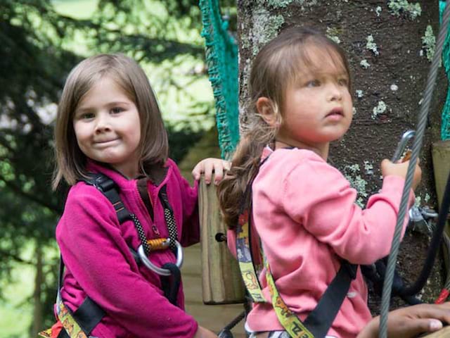 deux fillettes faisant de l'accrobranche en colonie de vacances cet été