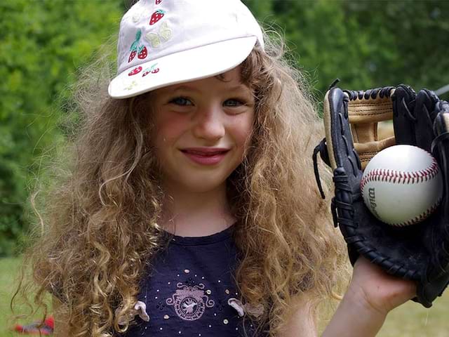 Fillette tenant une balle de baseball en colonie de vacances anglaise cet été