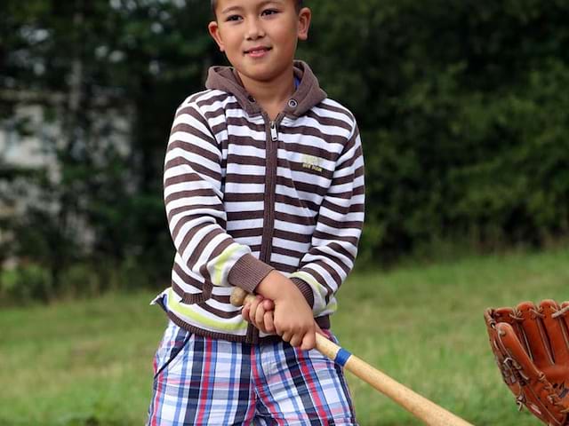 enfant apprenant à faire du baseball en colonie de vacances cet été