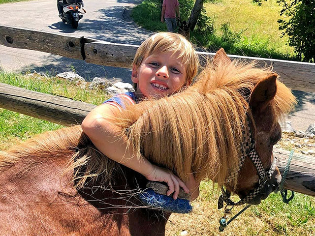 garçon câlinant un cheval lors d'une colonie de vacances dans le vercors