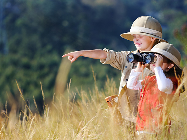 deux enfants observant la vallée à l'aide de jumelles
