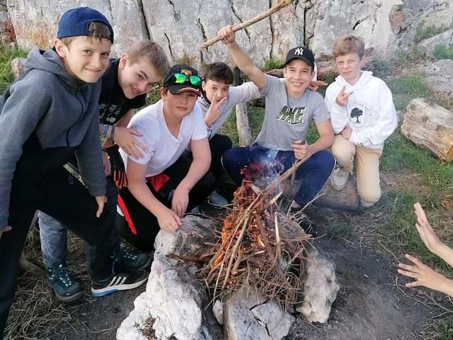 groupe d'enfants autour d'un feu en colonie de vacances cet été