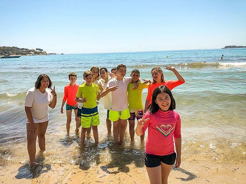 Jeunes enfants sur la plage qui profitent de leur colonie de vacances à la mer durant l'été