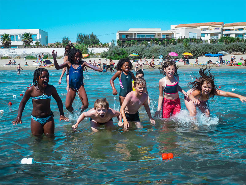 Groupe d'enfants qui profitent de la mer lors de leur colonie de vacances de l'été