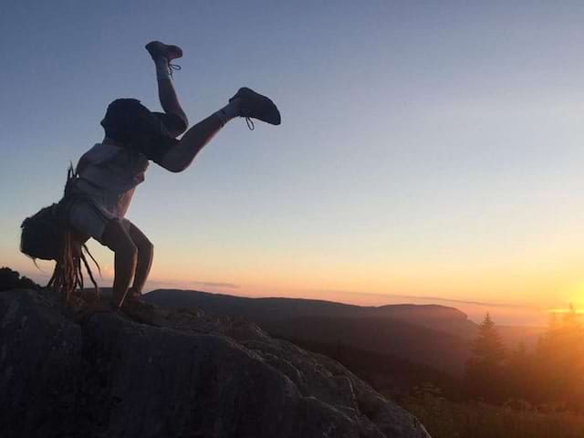 Enfant qui escalade un rocher la tête en bas