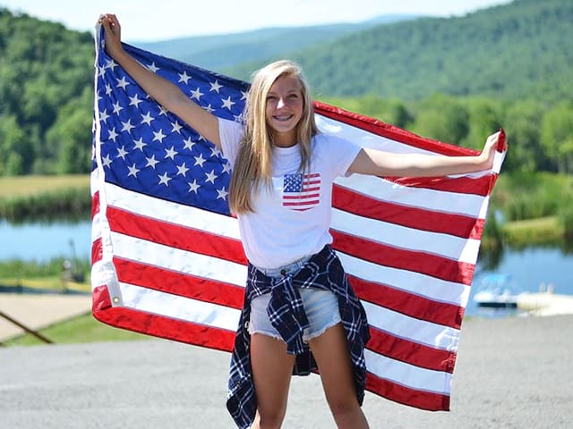 ado avec drapeau américain en colonie de vacances été