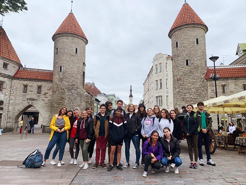 Groupe d'ados qui prennent la pose devant un célèbre bâtiment observé lors d'une colo de vacances en Finlande et en Estonie