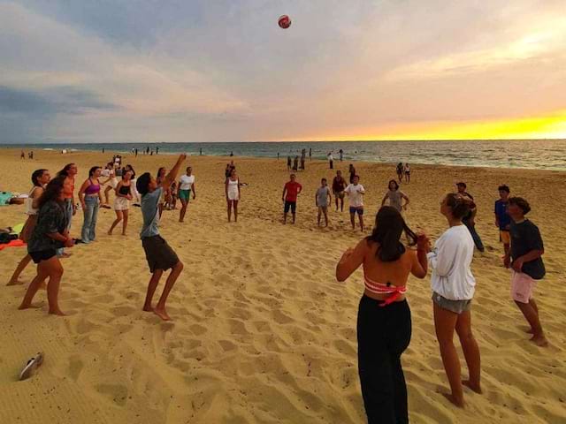 Groupe d'ados en train de s'amuser sur la plage en colo de vacances à l'océan cet été