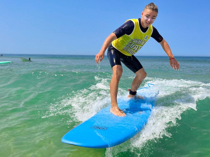 Ado levé sur sa planche de surf en colo de vacances Surf cet été à Capbreton