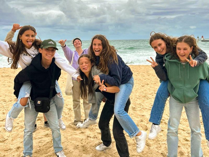 Groupe d'ados en colo de vacances qui s'amuse tous ensemble à la plage