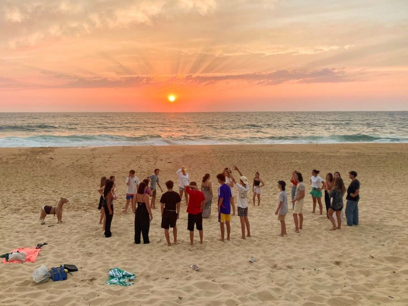 Groupe de jeunes qui admire le coucher du soleil en colo de vacances Surf à Capbreton