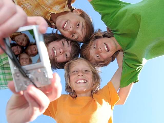 groupe d'ados avec un appareil photo en colo