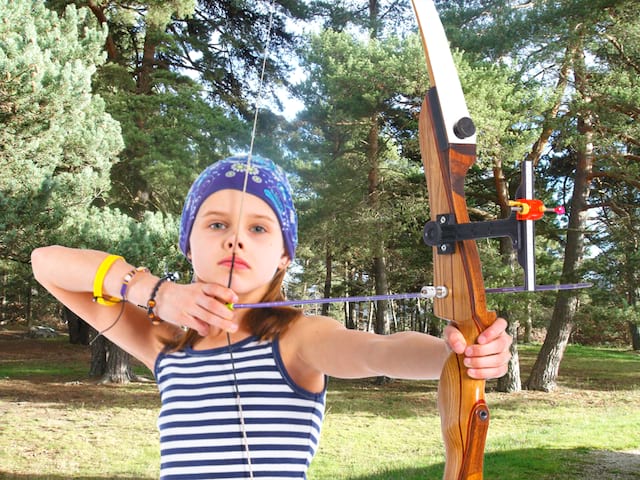 Jeune fille pratiquant le tir à l'arc en colonie de vacances