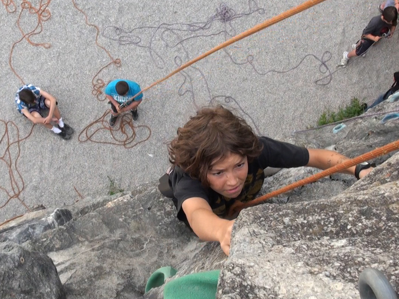 Enfant grimpant sur le mur d'escalade