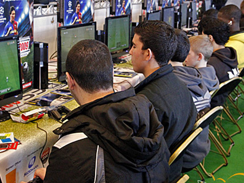 Groupe d'adolescents jouant en réseau sur ordinateur en colonie de vacances