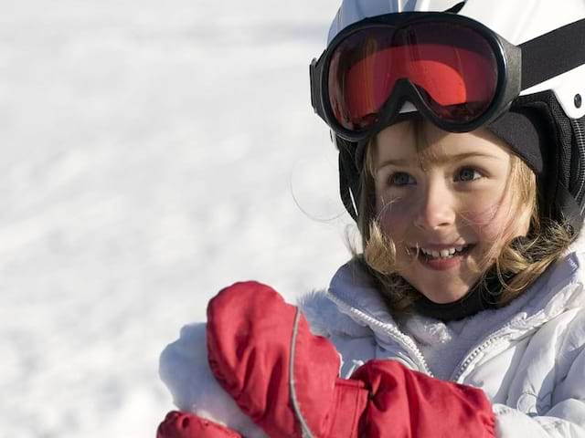 fillette préparant une boule de neige en colonie de vacances cet hiver