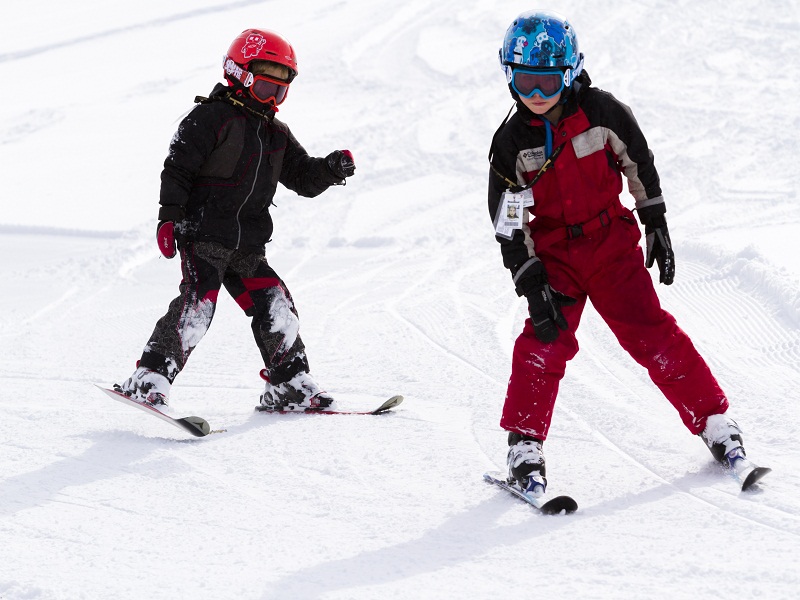 deux enfants apprenant à skier cet hiver dans une colonie de vacances spécialisée