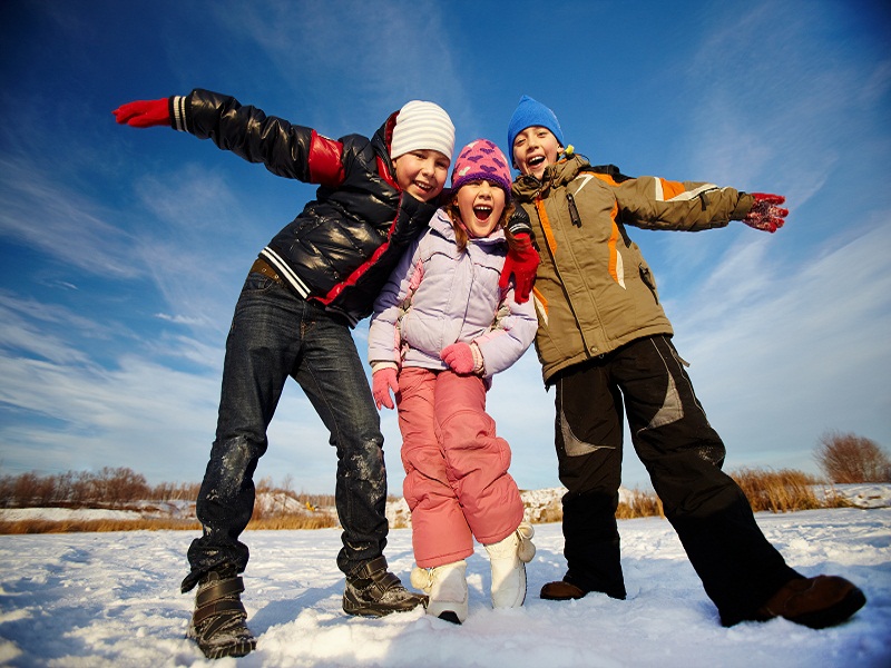 trois enfants sur la neige en colonie de vacances cet hiver