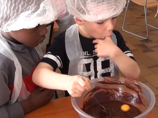 Enfants apprenant à cuisiner en colonie de vacances