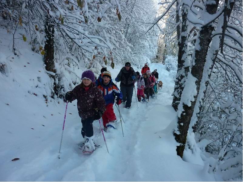 Enfants en randonnée à raquettes à la neige