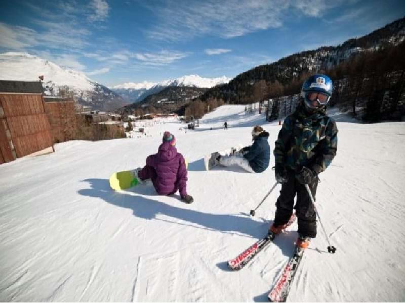 Enfants apprenant à faire du ski et du snowboard