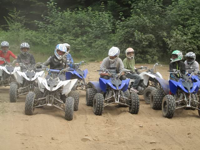 Groupe d'enfants faisant du quad dans les bois en hiver