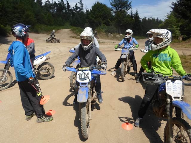 Groupe d'enfants apprenant à faire de la moto cross