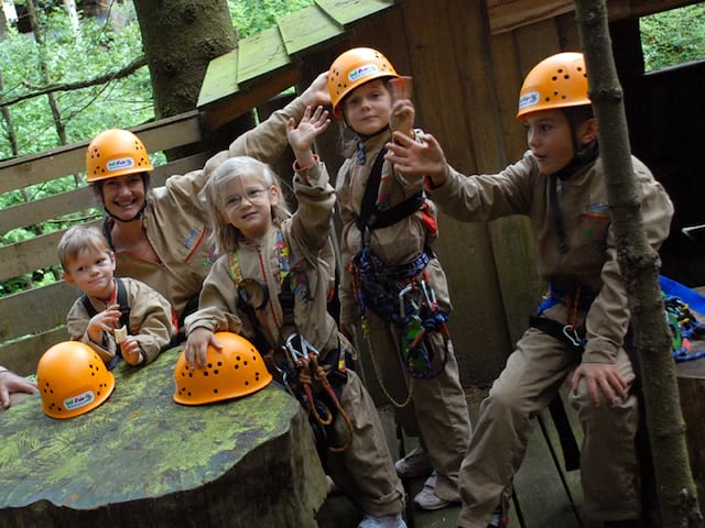 Groupe d'enfants qui font de l'accrobranche en colo