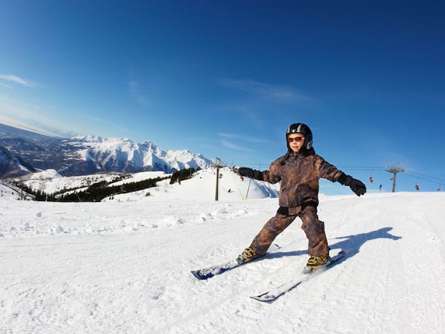 Petit garçon qui dévale les pistes à ski