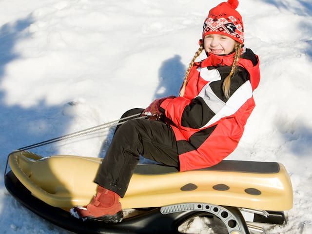 Jeune fille en train de faire de la luge