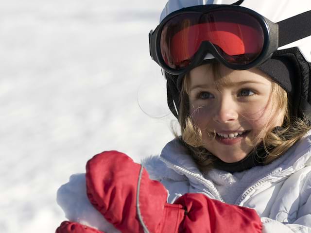 Petite fille à la neige en train de faire une boule de neige