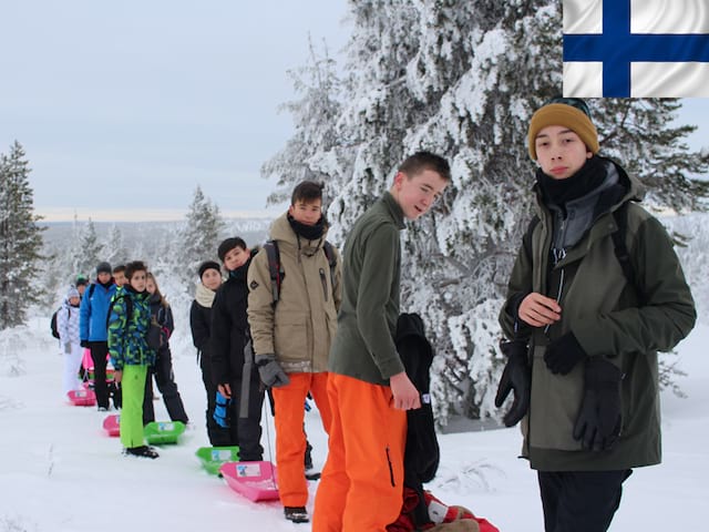 Groupe d'adolescents en colonie de vacances en Laponie en luge