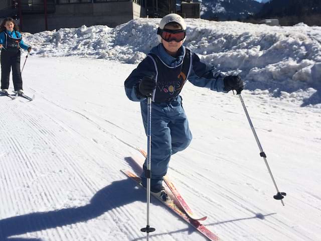 Enfant sur les pistes pratiquant le ski de fond en colonie de vacances de février