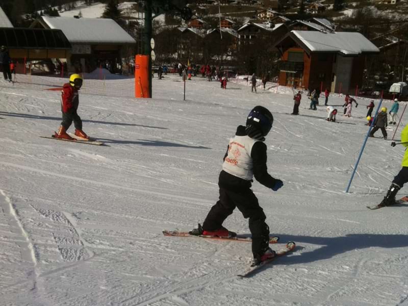 jeune garcon faisant du chasse neige sur une piste de ski
