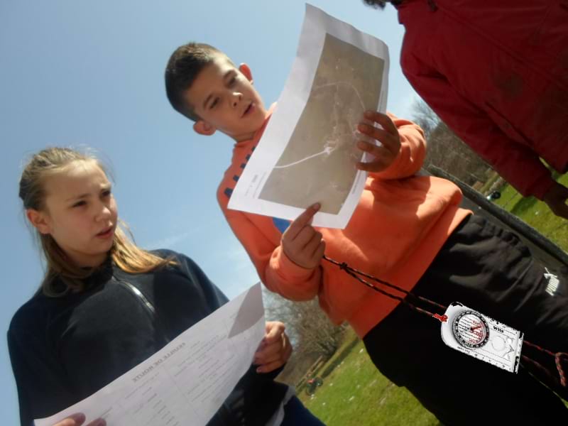 Groupe d'ados en course d'orientation à la campagne en colo