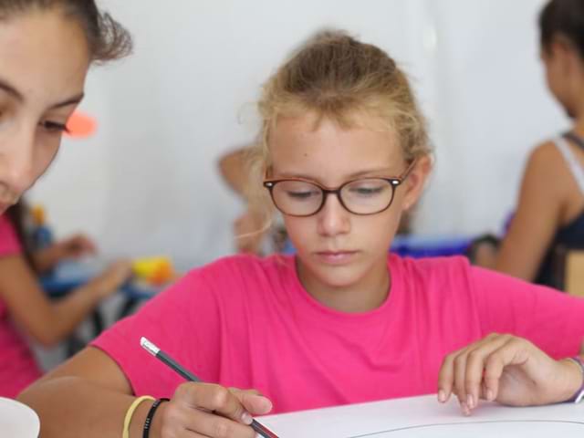 Fillette faisant des activités manuelles en colonie de vacances cet hiver