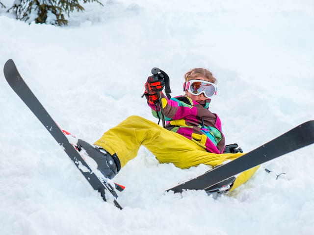 garçon en colonie de vacances couché dans la neige 